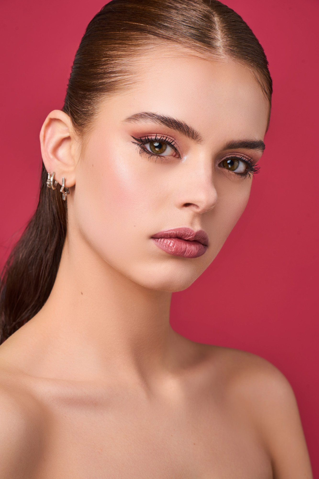 Model met een full glam make-up look met dubbele eyeliner in zachte roze tinten.