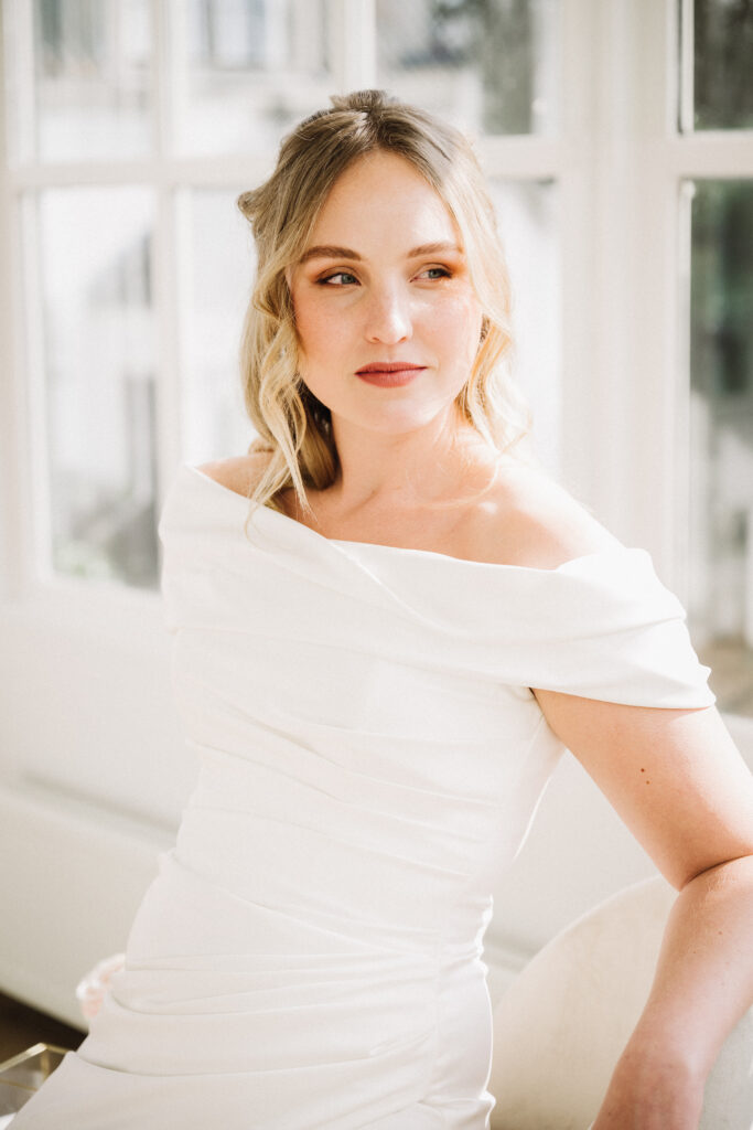 Romantische bruid met zachte make-up en half opgestoken krullen haar