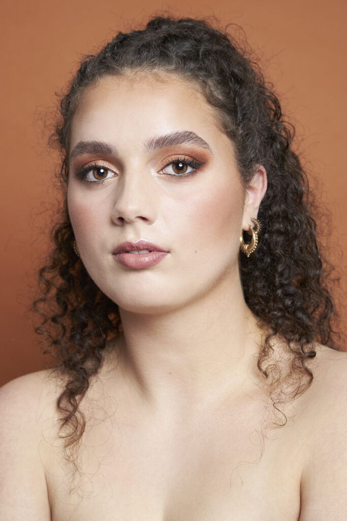 Model met een bronze make-up look met winged eyeliner.
