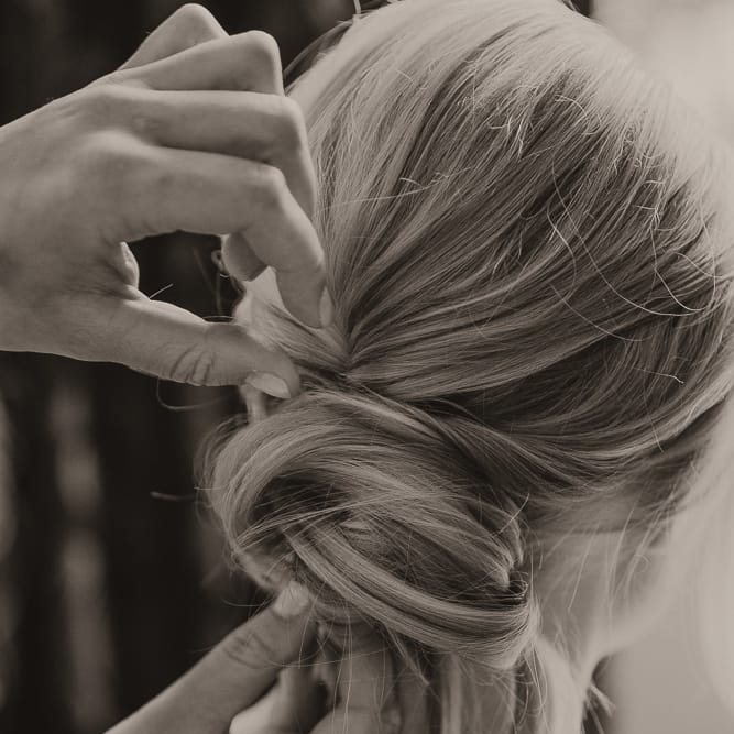 Bruidskapsel Zeewolde Flevoland. Stylist maakt een bridal updo bij bruid.
